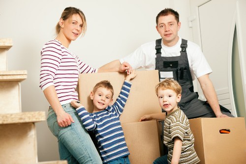 Professional movers carrying furniture on a residential street in Walthamstow Village