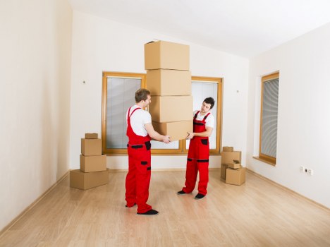 Moving team carrying boxes and furniture near a local East London property